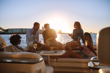 Group of friends partying on yacht at sunset - obrazy, fototapety, plakaty
