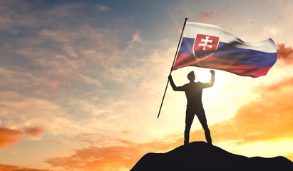 Slovakia flag being waved by a man celebrating success at the top of a mountain. 3D Rendering