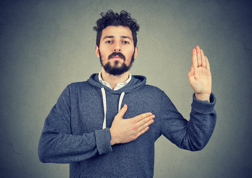 sincere man swearing with hand on heart