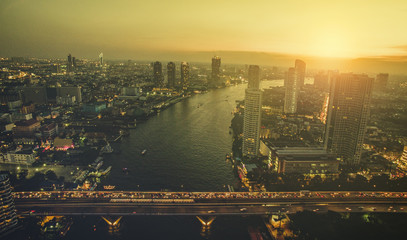 Fototapeta premium widok z lotu ptaka na zachód słońca niebo nad rzeką chaopraya i mostem sathorn w sercu stolicy tajlandii bangkoku
