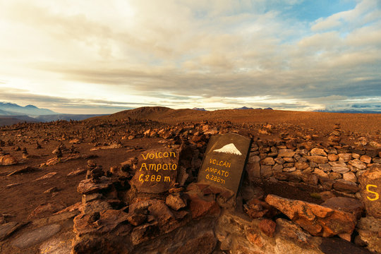 Ampato volcano seen at sunrise with a stone sign that indicates its height in the Patapampa viewpoint, Arequipa, Peru