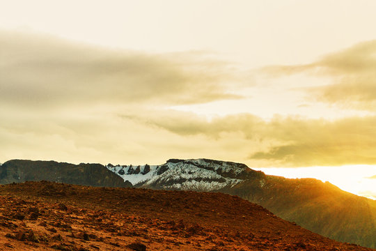 Snowy summits at sunrise with apachetas in front of a route in Arequipa, Peru