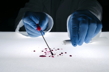 Forensic expert takes a blood sample with a sterile stick collecting evidence. Crime scene investigation concept.