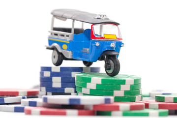 pile of casino chips and tuk tuk taxi on white background