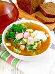 Okroshka in white bowl on wooden board
