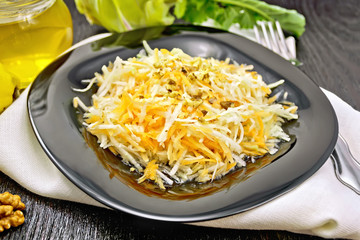 Salad of carrot and kohlrabi with honey in plate on black board