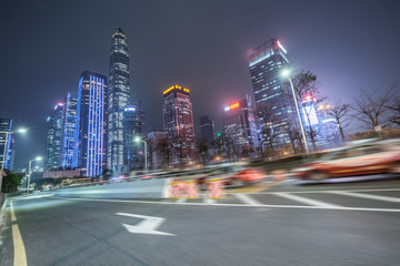 blurred road and modern office buildings at night