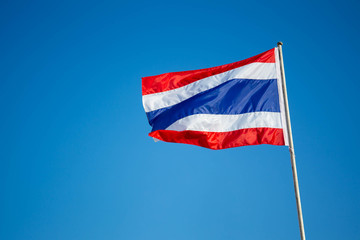 Fototapeta na wymiar Photograph of national Thai flag in the blue sky background.