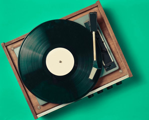 Retro vinyl player on a blue background. Entertainment 70s. Listen to music. Top view.