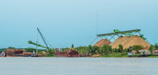 wood chip stockpile factory on Mahakam riverbank. industrial background