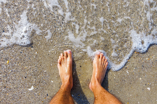 Selfie of man bare feet on sand beach and wave, summer concept