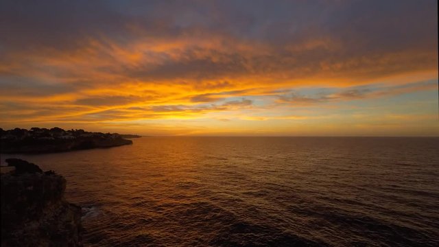Time lapse of a Fiery sunrise with multicolored clouds. Mallorca Island, Spain. Summer season