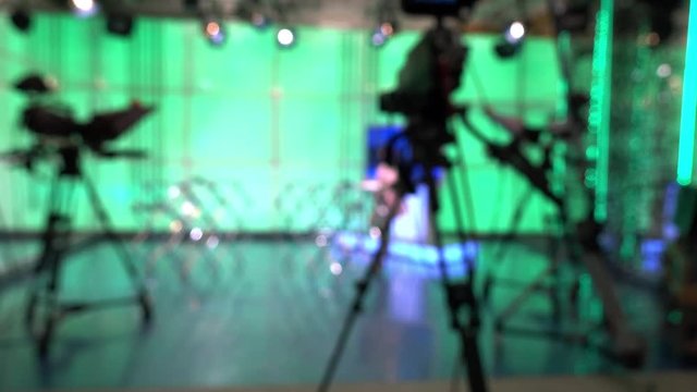 News Studio. Silhouette of a man and a digital video camera in front of a green screen.