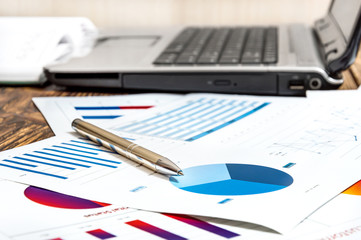 Pen on the business graphs at the workplace.