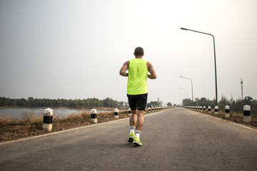 Athletic young man running on road . Healthy lifestyle.