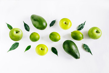 Green  fruits avacado, apples, lime and leaves creative concept top view on the white background.