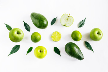 Green  fruits avacado, apples, lime and leaves creative concept top view on the white background.