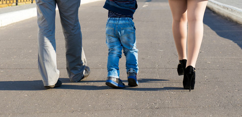 Father, mother and son walking in an urban neighborhood