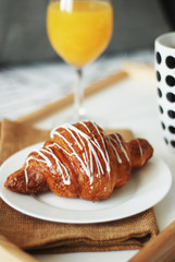 close up Breakfast in bed. Coffee and Croissants White Chocolate Food. Cup of Coffe or Tea. Morning light.