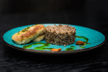 buckwheat porridge with a cutlet on a blue plate. Buckwheat cereal with schnitzel.