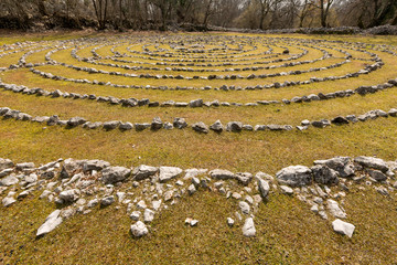 Labyrinth made of white stones on a green meadow near Beli on a sunny day in spring - obrazy, fototapety, plakaty