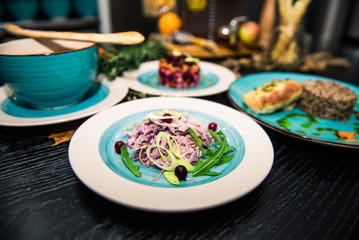 Vegetable salad. Sliced beef and fresh salad with purple onions, topped with balsamic mousse, rucola on the background of other dishes. Health food.