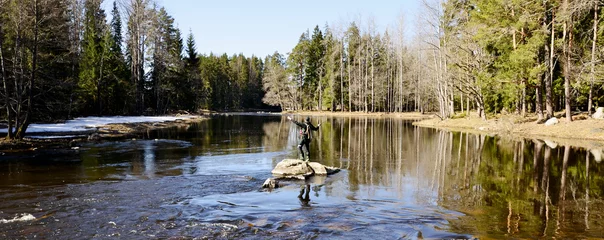 Fototapeten Fisherman casting in a salmon river at spring © Conny Sjostrom