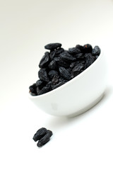 black raisins on white background