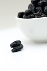 black raisins on white background