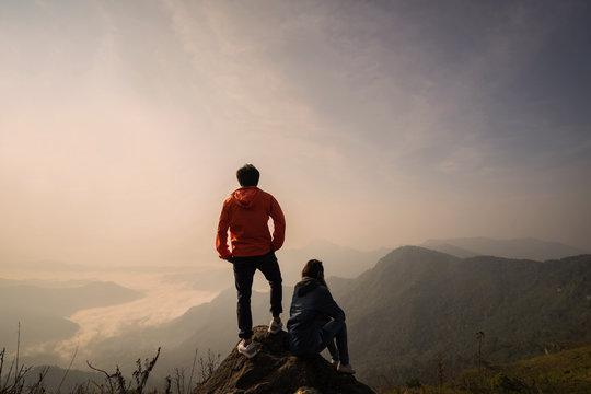 Young couple traveler standing and looking at beautiful landscape on top of mountain