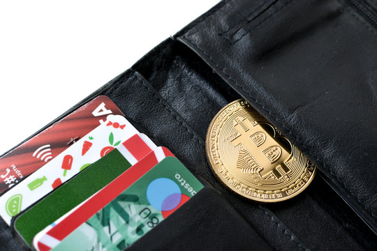 Purse with bitkoin and credit cards close-up.