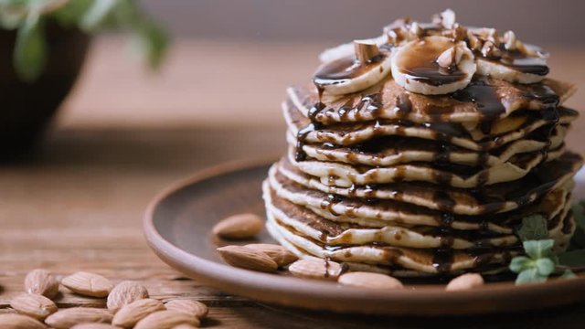 Homemade pancakes with banana, almonds and chocolate . Close up.