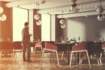 Corner of a loft cafe with red chairs, businessman