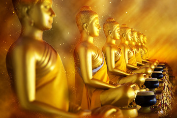 Golden statues of Buddha. Focus on the third figure.