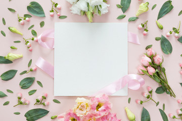 Top view of round flower frame with leaves and copy space isolated on pink background, flat lay. Greeting card concept