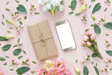 Flower arrangement on a white background with a mobile phone in a floral frame, top view and flat...