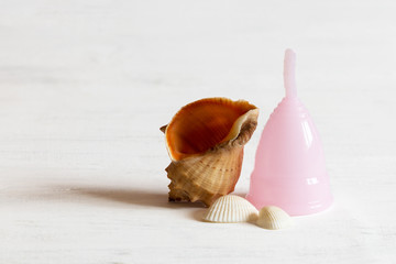 Pink menstrual cup and sells.  Selective focus, copy space.