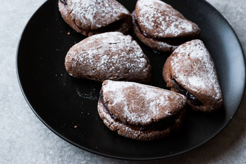 Jelly Filled Chocolate Cookies with Powdered Sugar and Cherry Jam.