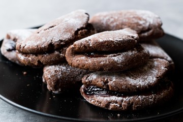 Jelly Filled Chocolate Cookies with Powdered Sugar and Cherry Jam.