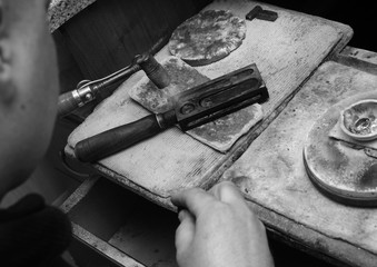 Black and white photo of the jeweler. The jeweler turned on the torch.