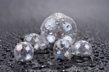 Transparent glass sphere with water drops isolated on black background