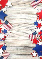 American independence Day, celebration, patriotism and holidays concept - flags and stars on the 4th of July party on top on wooden background