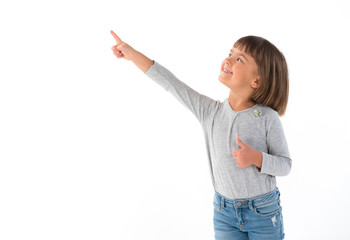 A young child looks up with heaved up a hand, on the white isolated background.