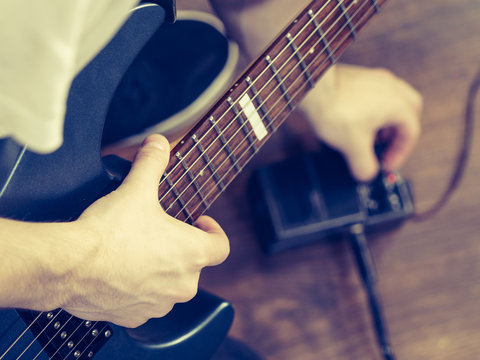 Man adjusting guitar effects pedal