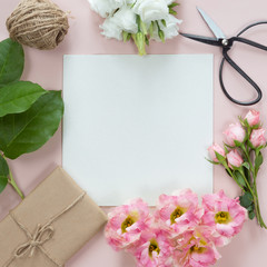 Festive composotion with flowers, notebook, gifts, scissors, ribbons, leaves on a white background, top view and flat lay, floral frame