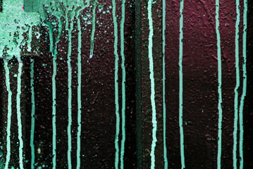 Green spray of paint on a red wall close, concept of vandalism