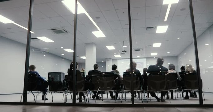 Business team meeting businessman presenting crowdsourcing plan idea to tech startup investors. Back view