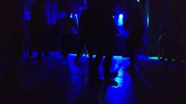 Silhouettes of the steping DnB dancing people at a party