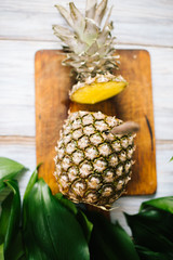 Ripe bisected ripe pineapple on a wooden background