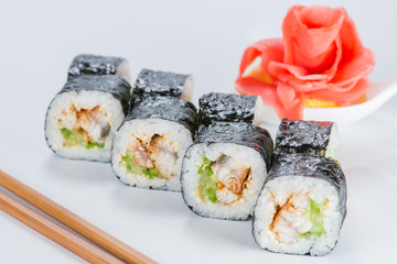 Appetizing fresh sushi rolls with rice, shrimps, avocado and cucumber on light background